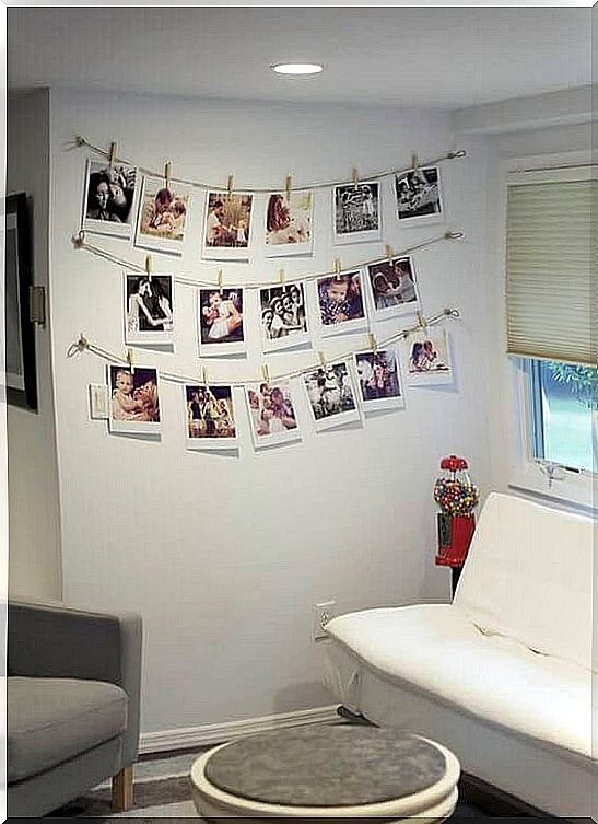 Decorate the room with photos by hanging them on strings on a wall.