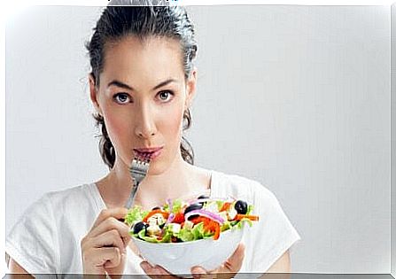 a woman eats a salad to avoid epigastralgia