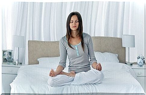 woman meditating on the bed